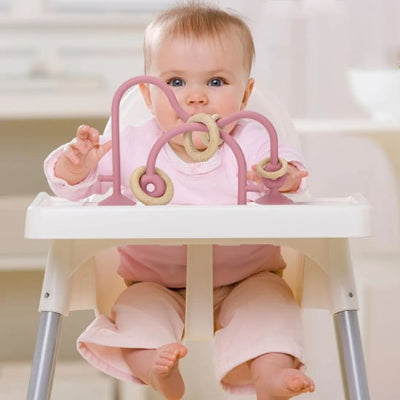 bébé avec anneau de dentition rose beige