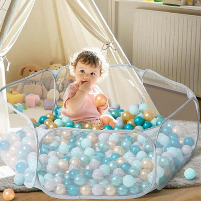 bébé assis dans piscine a balle