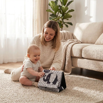 bébé avec livre bébé éléphant en compagnie maman contente  au salon
