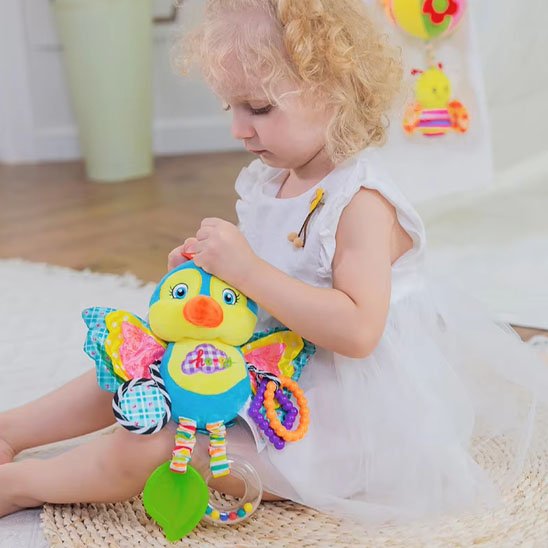 enfant manipule hochet oiseau